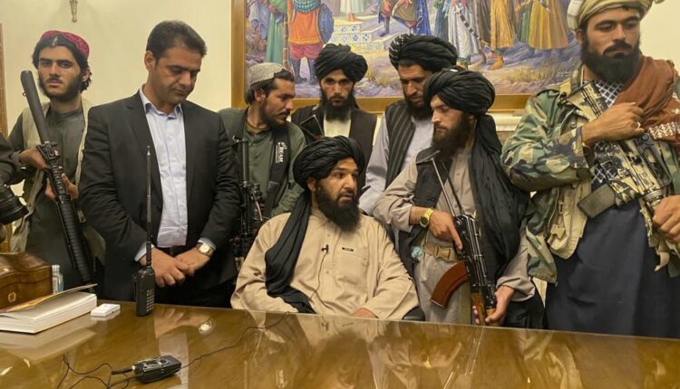 Taliban fighters take control of Afghan presidential palace after the Afghan President Ashraf Ghani fled the country, in Kabul, Afghanistan, Sunday, Aug. 15, 2021. Person second from left is a former bodyguard for Ghani.