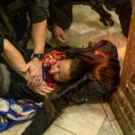 Law enforcement entities claim that the woman was shot by Capitol Police. Once shot and fell on the floor of the Capitol, police gathered around her trying to save her while calling for help, rioters all gathered around the female filming and shouting