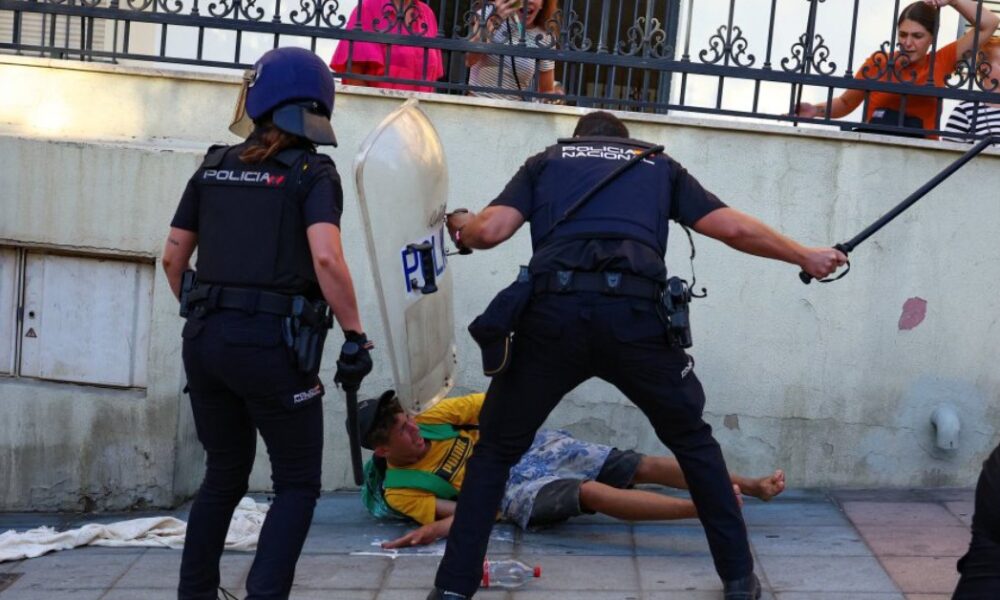 A Spanish policeman strikes a migrant with a baton in the occupied Ceuta